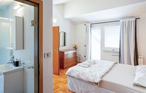 A hotel room with a bed, a wooden dresser, a mirror, a window with curtains, and a radiator. - 2 bedroom amazing home in Pazin (Pazin)