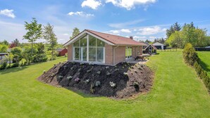 A modern house with a glass extension, a patio, and a well-maintained garden. - Pet friendly home in Farsø with sauna (Farsø)
