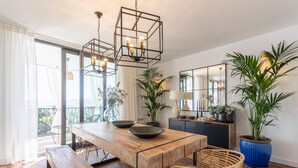 A modern dining area with a wooden table, bench, and hanging light fixture. - Beautiful home in Nigüelas (Nigüelas)