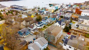 An aerial view of a coastal town with houses, a marina, and a large body of water.