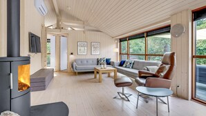 Una sala de estar acogedora con chimenea, un sofá, una mesa de centro y un sillón de cuero.