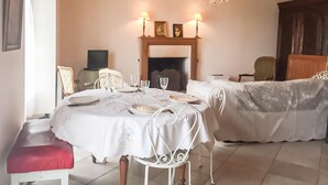 Un comedor con una mesa dispuesta para dos, chimenea y candelabro.