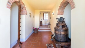 A hallway with brick arches, a wooden barrel, and a lantern. - Cozy home in Cortona with kitchen (Cortona)