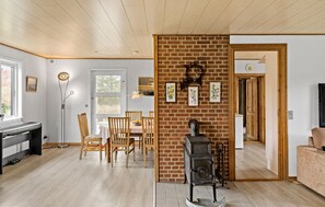 Ein gemütliches Wohnzimmer mit Kamin, Holzmöbeln und einem Klavier.