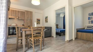 Un espace de vie compact comprenant une cuisine, un coin repas et une chambre.