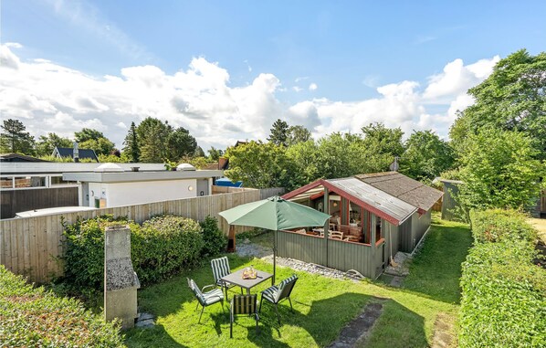 A backyard with a wooden deck, a barbecue area, and a small shed. - 1 bedroom amazing home in Stege (Stege)
