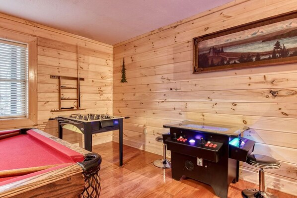 A cozy room with a pool table, foosball table, and a bar area. - Running Bears Den- Chalet Village’s Perfect Retreat in the Mountains (Gatlinburg)