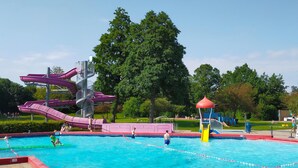 Une piscine avec un toboggan et un espace de jeux pour enfants.