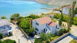 A coastal property with a white building featuring a red-tiled roof, a staircase, and a pool. - 4 bedroom amazing home in Povljana (Povljana)