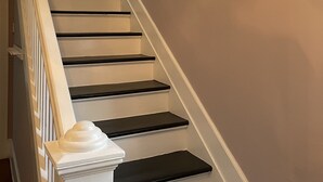 A staircase with white and black steps, a white handrail, and a white balustrade. - The Painted Lady, a spacious renovated 4BR Victorian (St. Augustine)