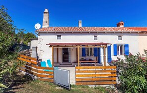 A two-story house with a tiled roof, a chimney, and a small balcony with blue shutters. - Amazing home in Labin with house sea view (Labin)