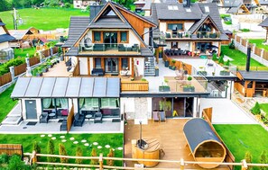 Un complexe résidentiel moderne comprenant plusieurs maisons, chacune dotée d’un balcon, d’un espace salon extérieur et d’une grande terrasse.