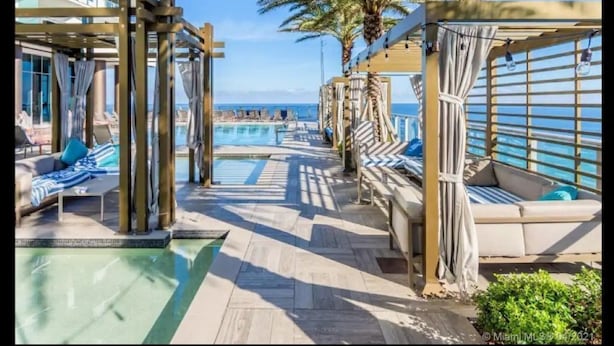 A poolside area with lounge chairs, a wooden pergola, and a view of the ocean. - Hyde Resort Hollywood Full Amenities BOOK NOW! (Hollywood)