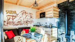 Una cucina accogliente con mobili in legno, un fornello e un'area pranzo con un tavolo in vetro.