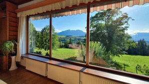 A room with large windows overlooking a green landscape and mountains. - Ferienhaus - St. Koloman (St. Koloman)