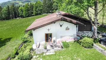 Ein weißes Gebäude mit rotem Dach, Steinstufen und einer Steinmauer.