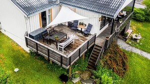 A house with a covered patio, a deck, and a small garden area. - Gorgeous home in Vestnes with WiFi (Vestnes)