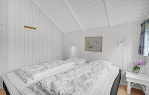 A bedroom with a large bed, a bedside table, a lamp, and a framed picture on the wall. - Cozy home in Væggerløse with sauna (Væggerløse)