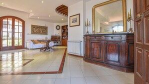 Uma sala de estar espaçosa com um grande armário de madeira, uma mesa de jantar e um sofá.