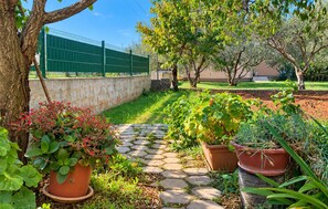 A garden pathway with potted plants and a green fence in the background. - 4 bedroom amazing home in Sukosan (Sukosan)