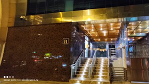 L’entrée d’un hôtel, avec une façade en marbre, un escalier et une enseigne indiquant « Lima Central Design Hotel Spa Club ».