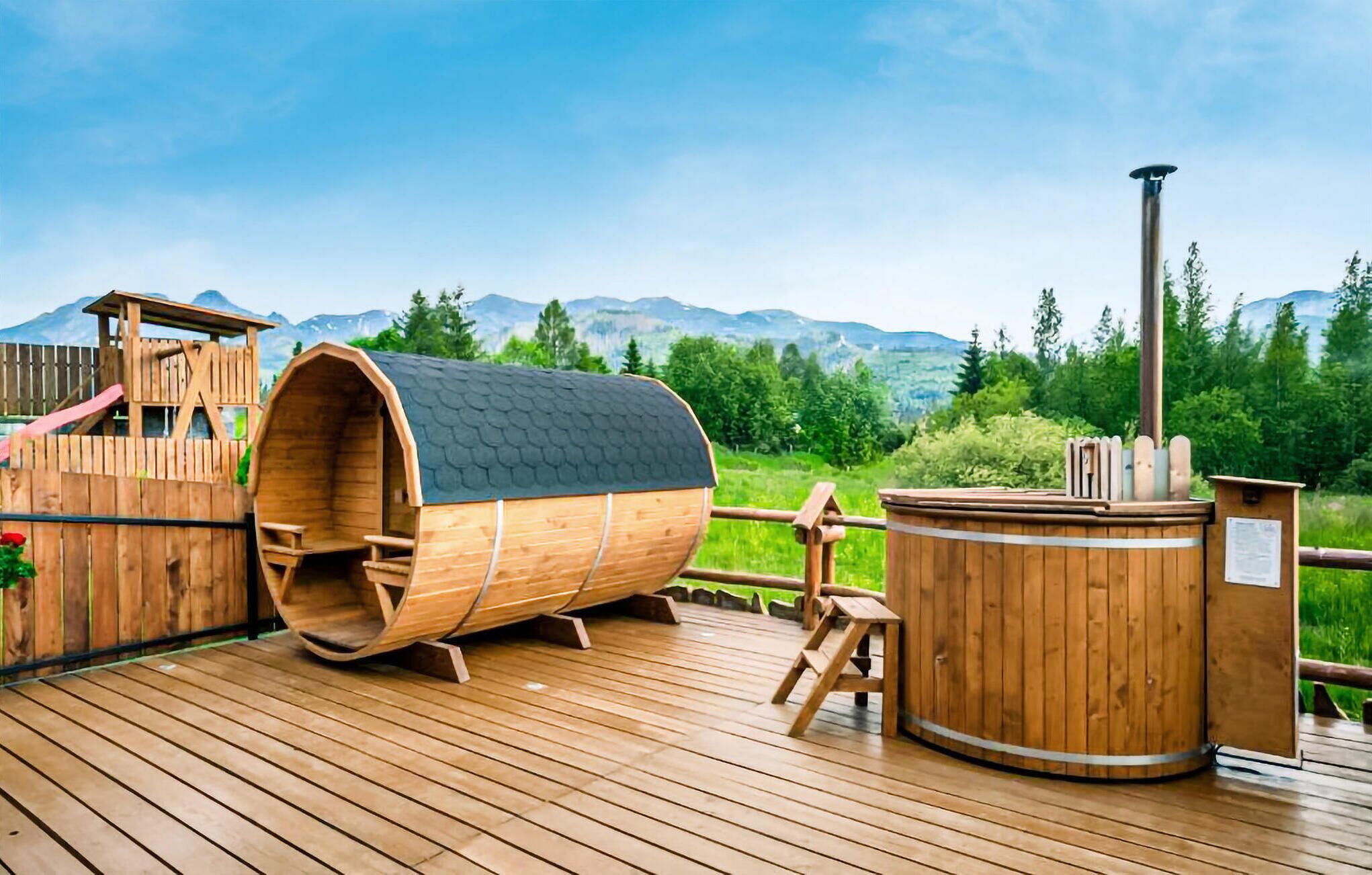 A wooden deck with a sauna, a wooden play structure, and a hot tub.