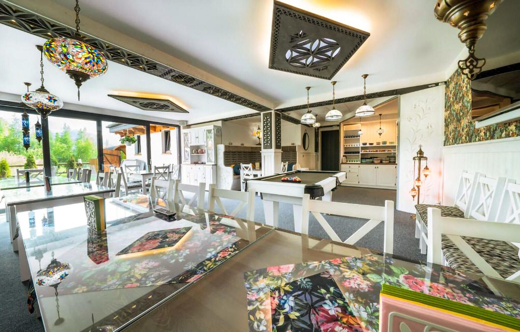 Une pièce spacieuse comprenant une table de billard, un coin repas et une cuisine.