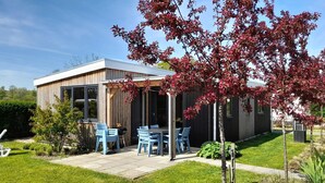 A modern house with a patio, outdoor seating, and a garden. - 3 bedroom nice home in Heinkenszand (Heinkenszand)