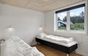 Cozy retreat with a single bed and window offering a view of the surrounding greenery.