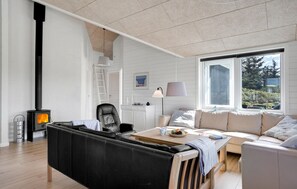 Relax in this spacious living room with a high ceiling, large window, and comfortable seating area.
