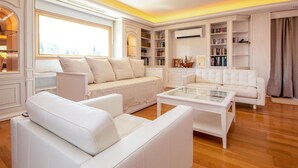 A spacious living room with white leather sofas, a glass coffee table, and built-in bookshelves. - Beautiful home in Mijas Costa with sauna (Mijas Costa)