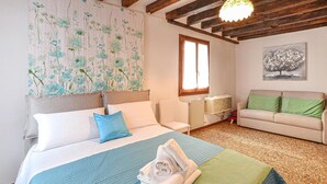 A bedroom with a bed, a sofa, a radiator, and a window. - Lovely apartment in Venezia with WiFi (Venezia)
