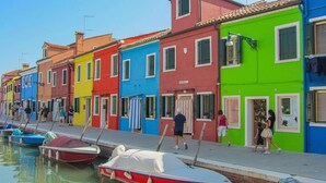 A row of colorful buildings along a waterfront with boats docked in the water. - Lovely apartment in Venezia with WiFi (Venezia)