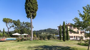 A villa with a pool, surrounded by a well-maintained lawn and tall trees. - Stunning home in Chiusi (Chiusi)