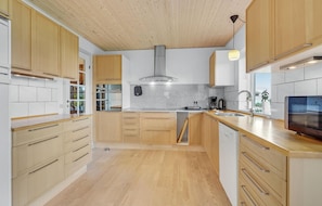 Enjoy cooking in this well-lit kitchen with a large island and stainless steel range hood.