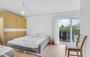 Relax in this serene bedroom with a single bed, bedside table, and large window offering a view of the surrounding area.