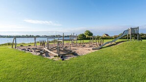 A playground with a slide and swings by a lake. - Cozy home in Gråsten with kitchen (Gråsten)