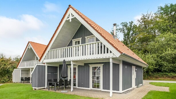 A two-story house with a balcony, a covered patio, and a chimney. - Cozy home in Gråsten with kitchen (Gråsten)