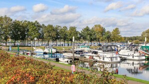 A marina with various boats docked, surrounded by trees and a calm water body. - Awesome home in Well with kitchen (Well)