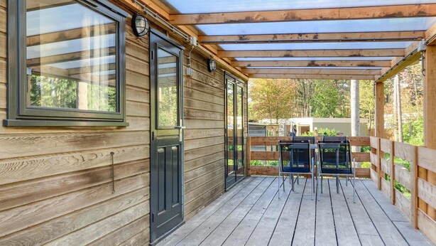 A wooden deck with a covered area, a door, and a table with chairs. - Awesome home in Well with kitchen (Well)