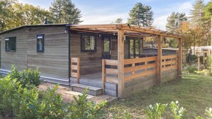 A small, single-story wooden cabin with a covered porch and a small deck. - Awesome home in Well with kitchen (Well)