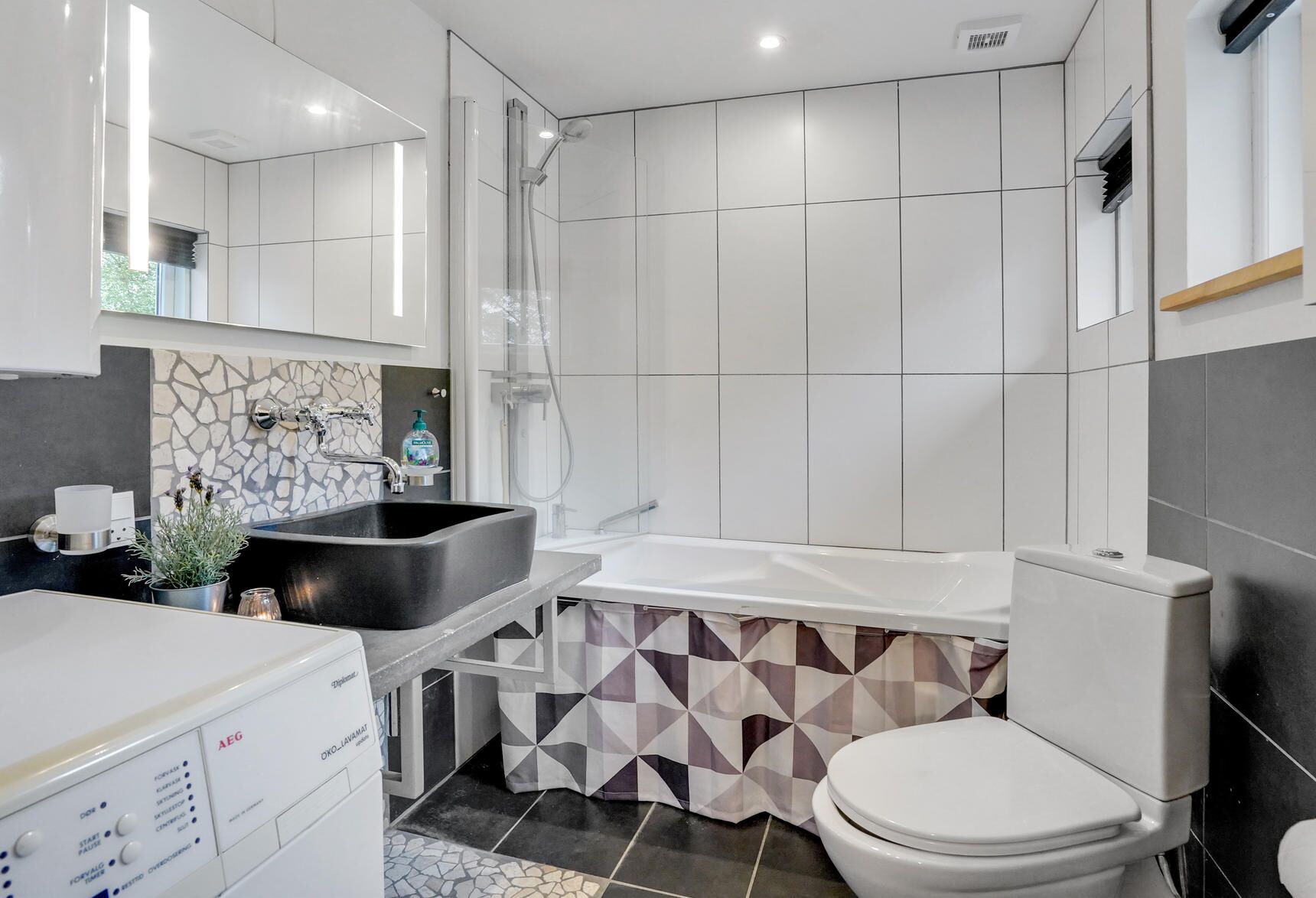 Une salle de bain moderne avec un grand lavabo, une baignoire et des toilettes.