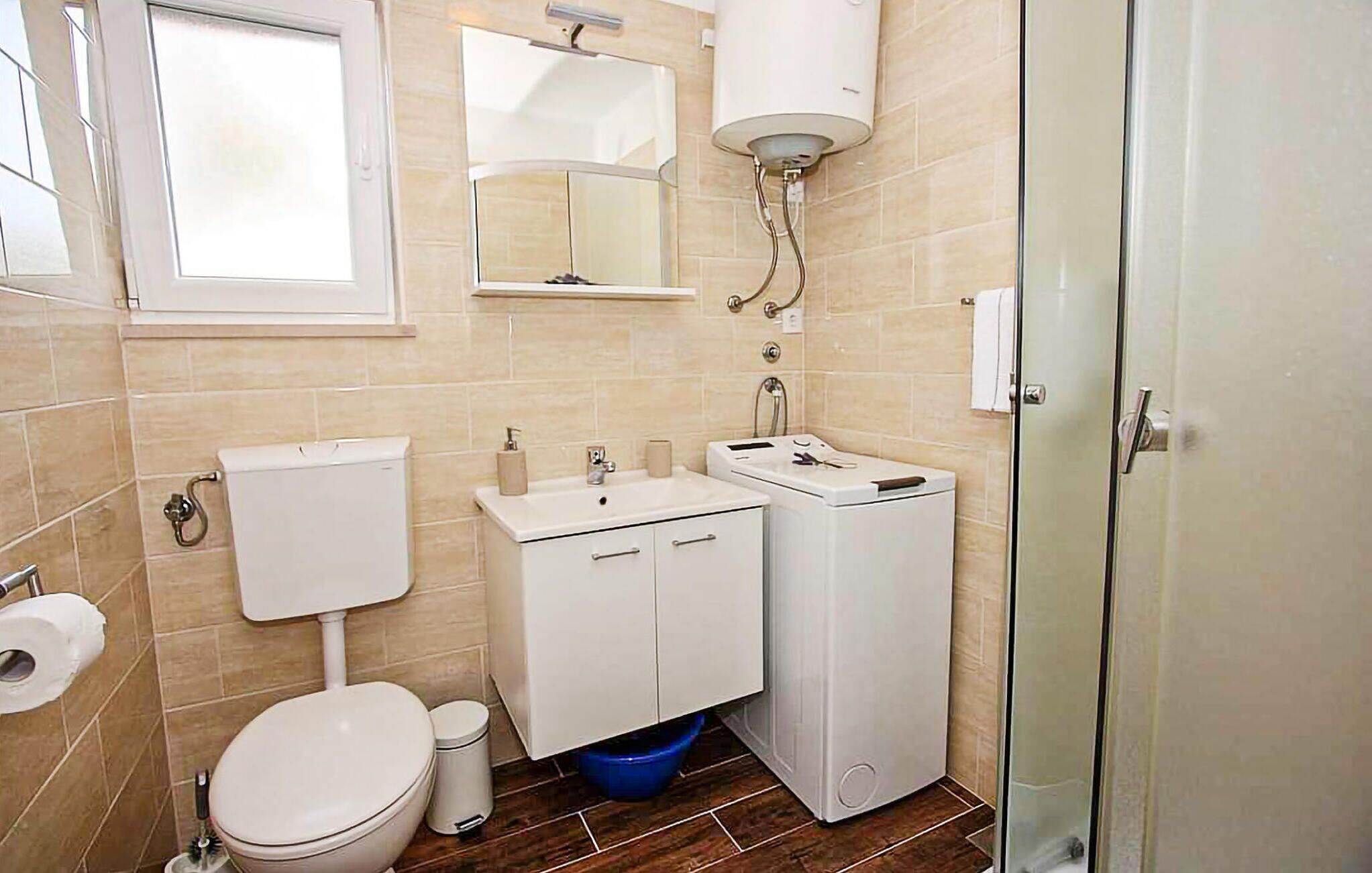 A compact bathroom with a toilet, sink, and shower.