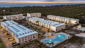 Un hôtel à plusieurs étages doté d’une piscine, de places de stationnement et offrant une vue sur l’océan.