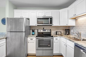 Enjoy cooking in this well-equipped kitchen with a refrigerator, microwave, oven, and dishwasher.