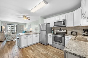 Enjoy cooking and dining in this well-equipped kitchen with an oven, microwave, and large island with a sink.