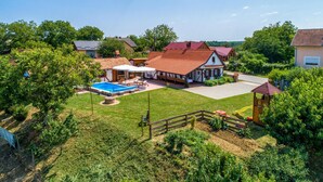Ein Wohnhaus mit Swimmingpool, überdachter Terrasse und umzäunter Garten.