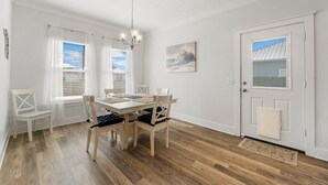 Ein Essbereich mit Holztisch und Stühlen, einer Kandelaber und einem Gemälde an der Wand.