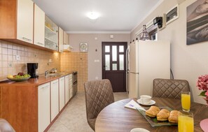 Enjoy a homey meal in this kitchen with a central island, dining area, and comfortable seating.