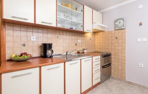 Enjoy cooking in this well-equipped kitchen with a coffee maker, sink, oven, and ample storage.